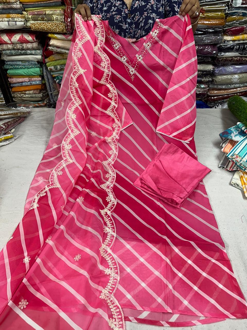 a woman holding a pink and white striped sari